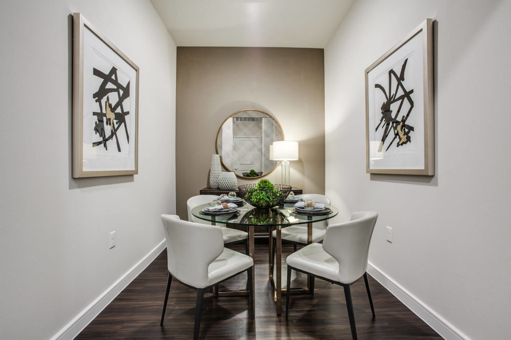 Dining nook with wood-style floors, accent wall, and table with 4 chairs