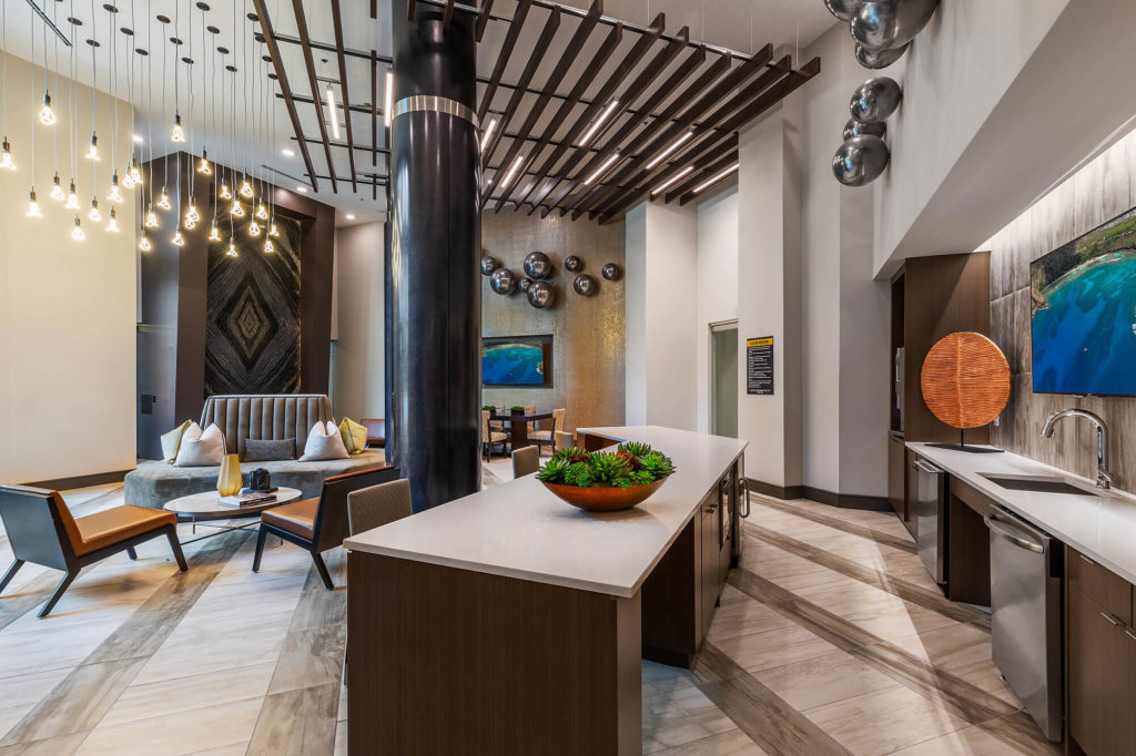 Clubhouse kitchen with dishwashers, sink, seating, artistic lighting and counter space