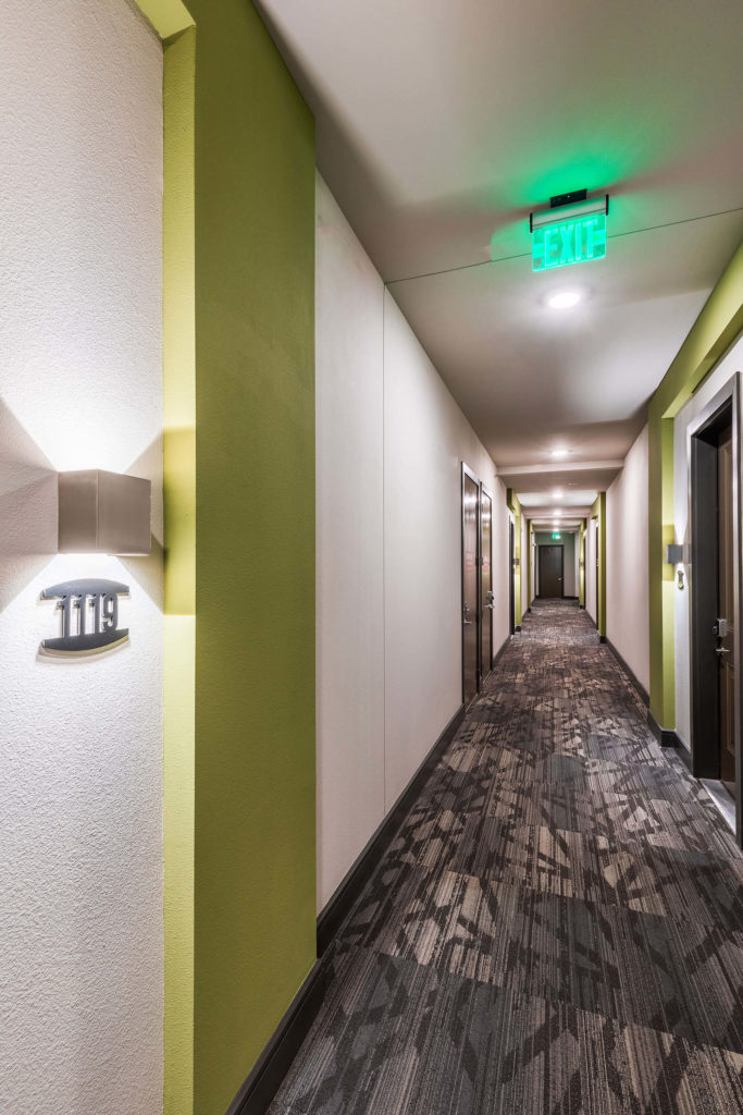 Apartment hallway with exit sign and accent colors