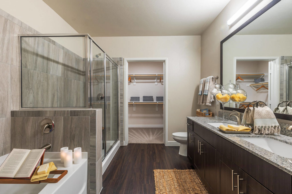 Bathroom with large walk-in shower, soaking tub, wood-style floors, dual vanity, and walk-in closet
