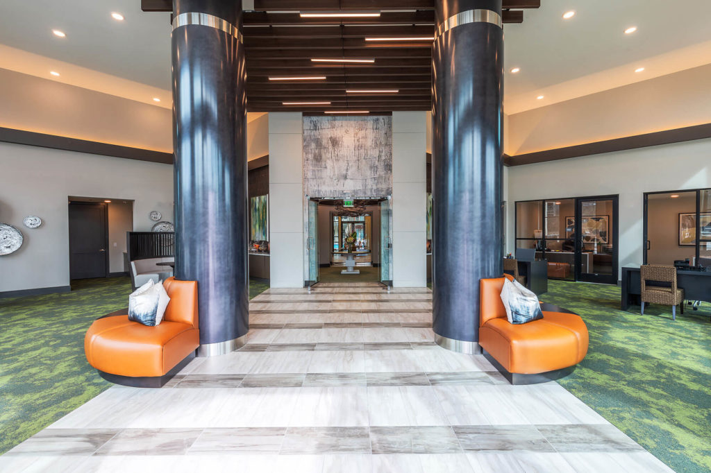 Lobby entrance with decorative pillars, modern furniture, desks and additional seating